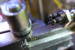 Spoke partially inserted into spoke threading machine